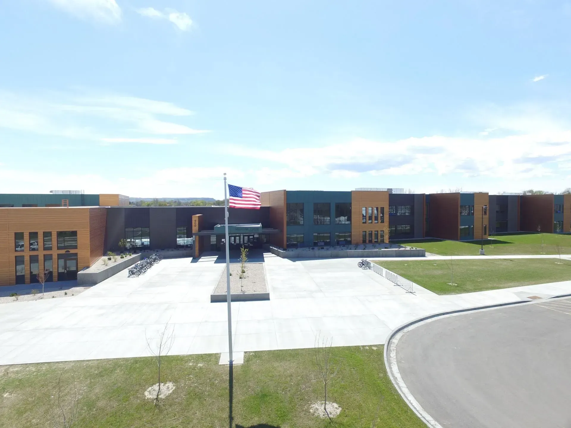 An American flag is flying in front of a large building.