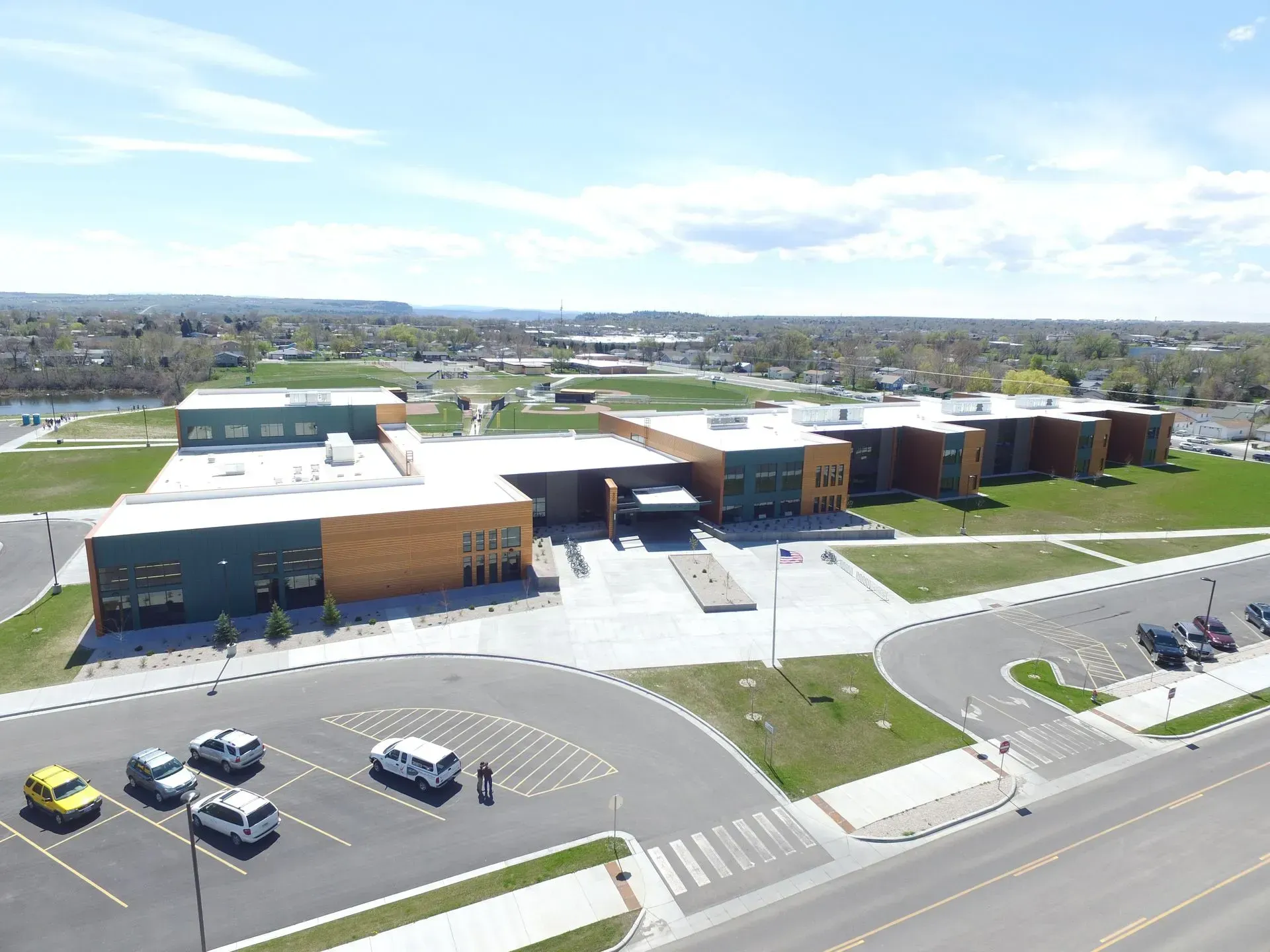 An aerial view of a large building with cars parked in front of it.