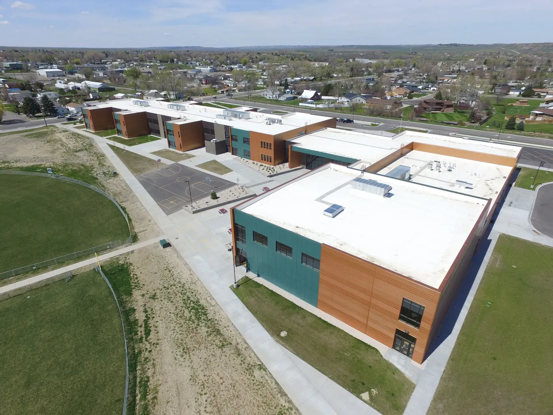 An aerial view of a school with a white roof