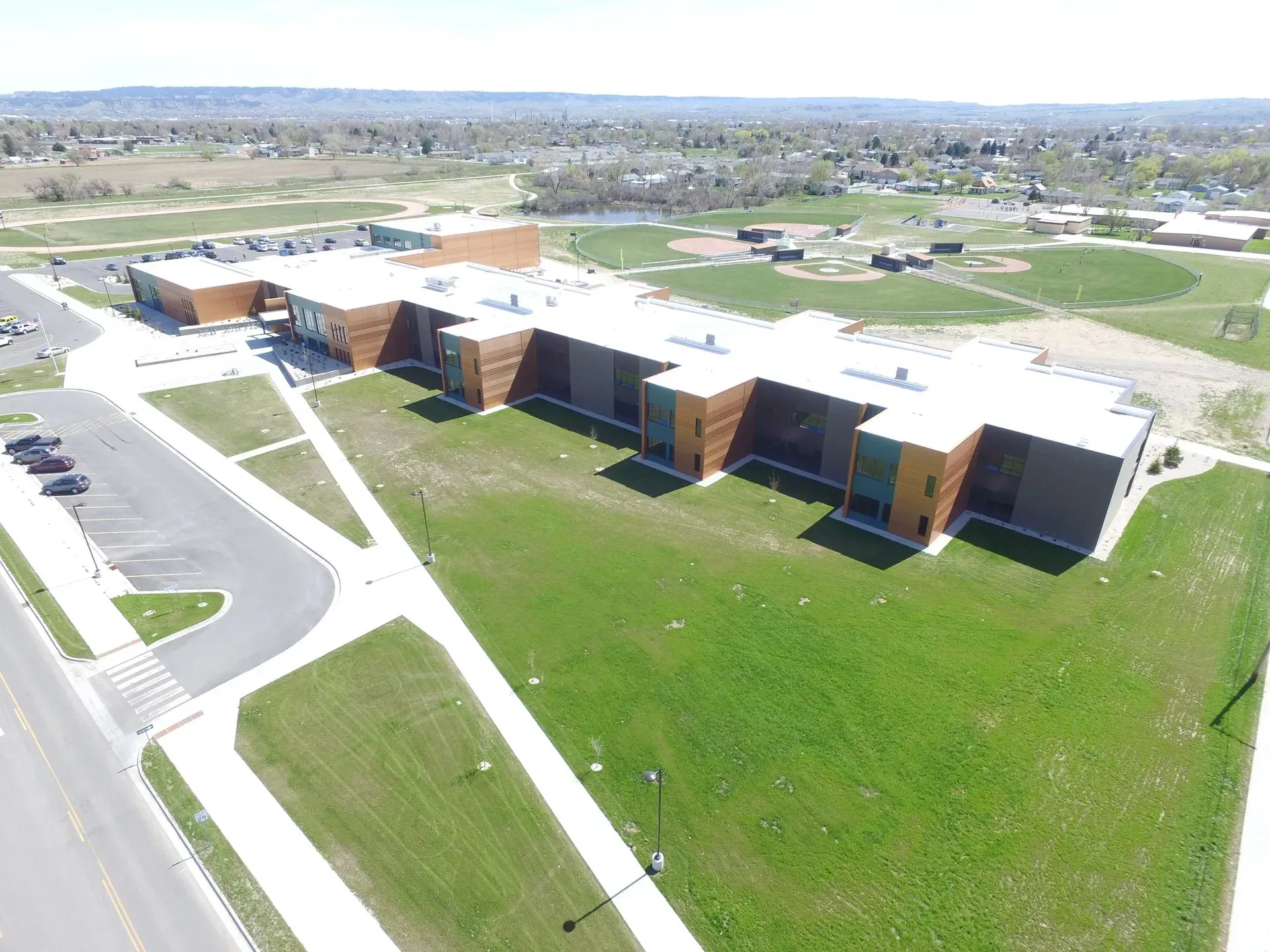 An aerial view of a large building with a lot of grass in front of it.