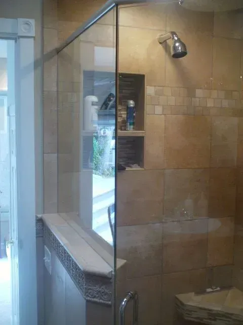 A bathroom with a glass shower door and a shower head.