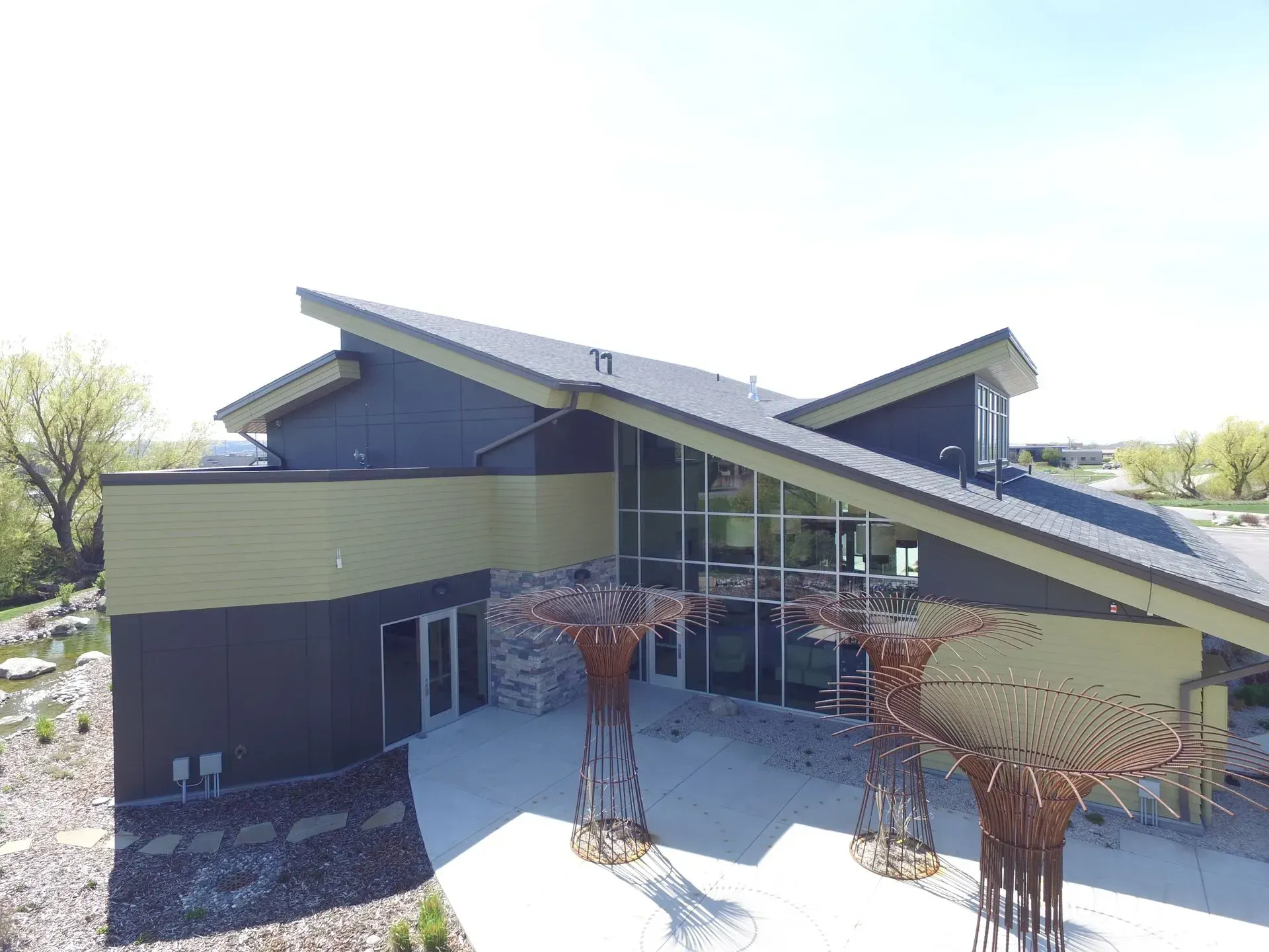 An aerial view of a large building with a sculpture in front of it.