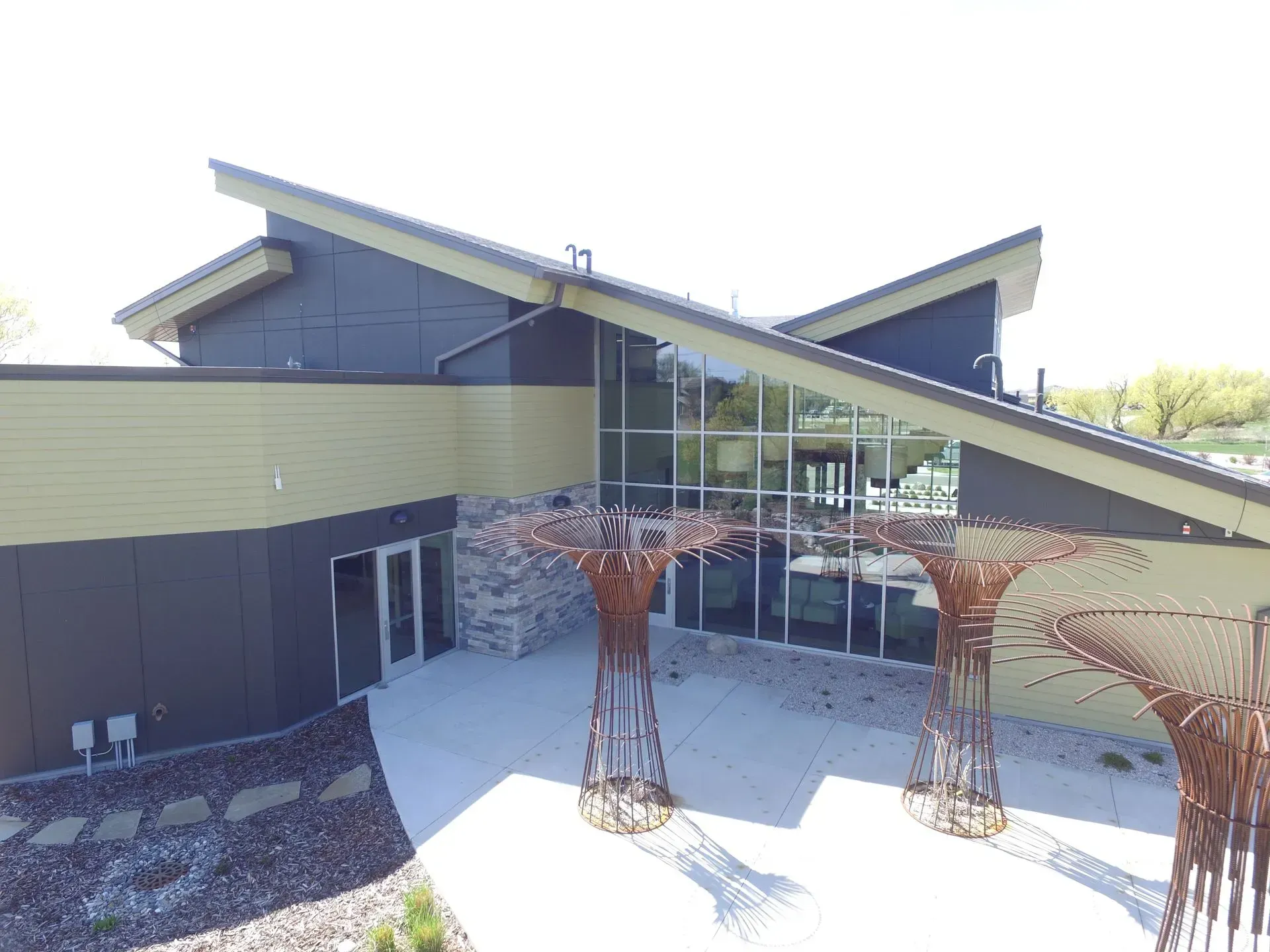 A large building with a lot of windows and a sculpture in front of it.