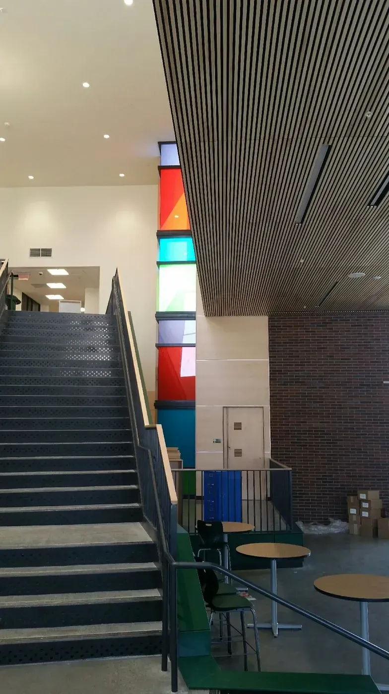 A staircase in a building with tables and chairs