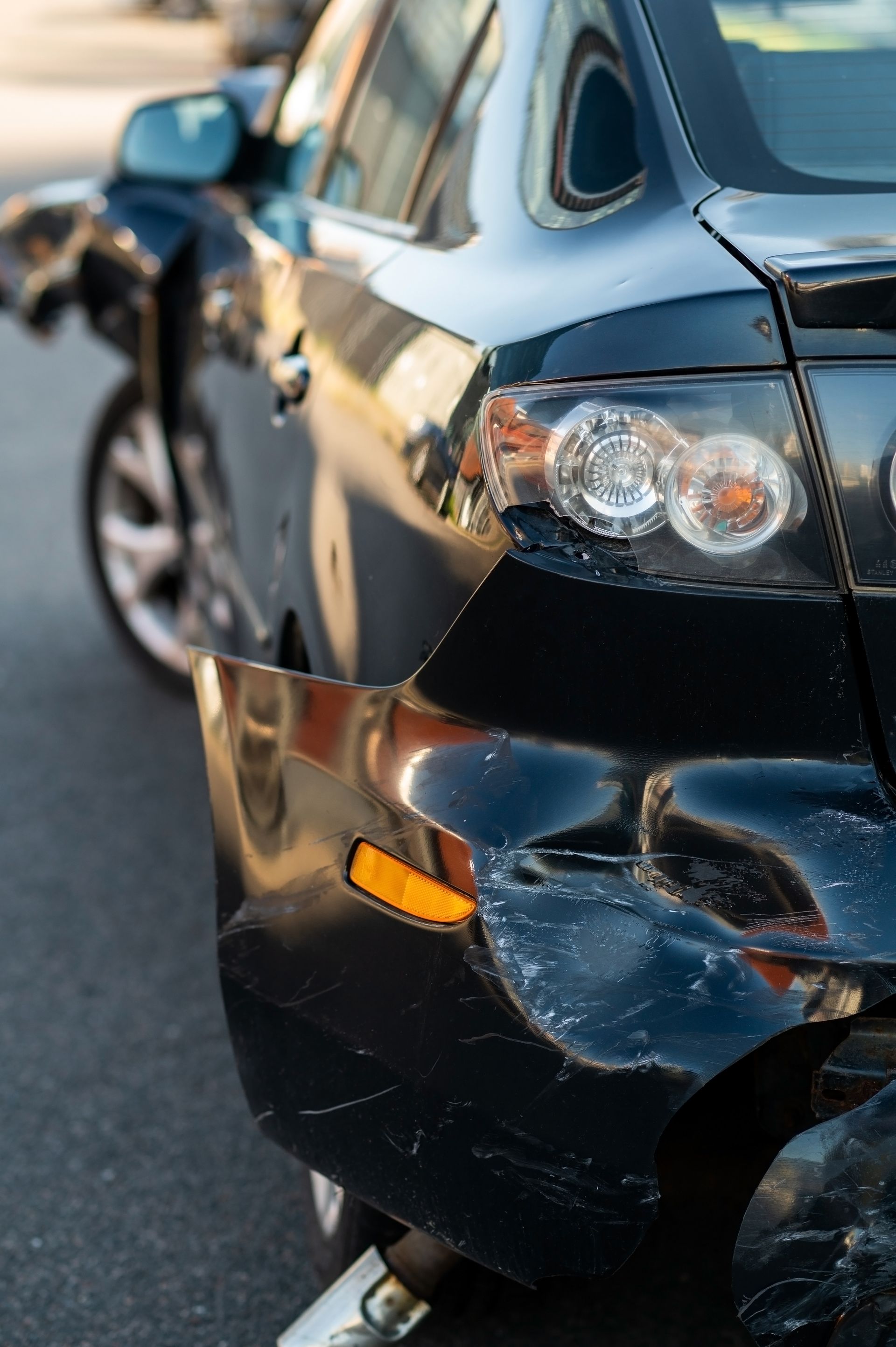 Cars in traffic during a rainstorm, illuminated taillights, blurred lights in the distance.