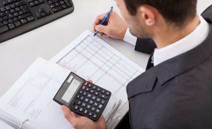 a man calculating and writing tax details