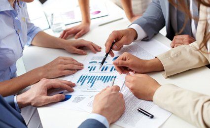 People sitting around a graph of figures
