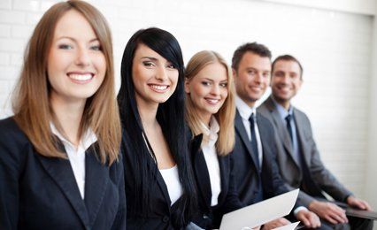 A row of young men and women in business suits
