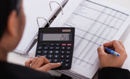 A man using a calculator to add up some figures