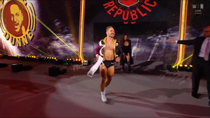 A man is walking on a stage in front of a sign that says republic.