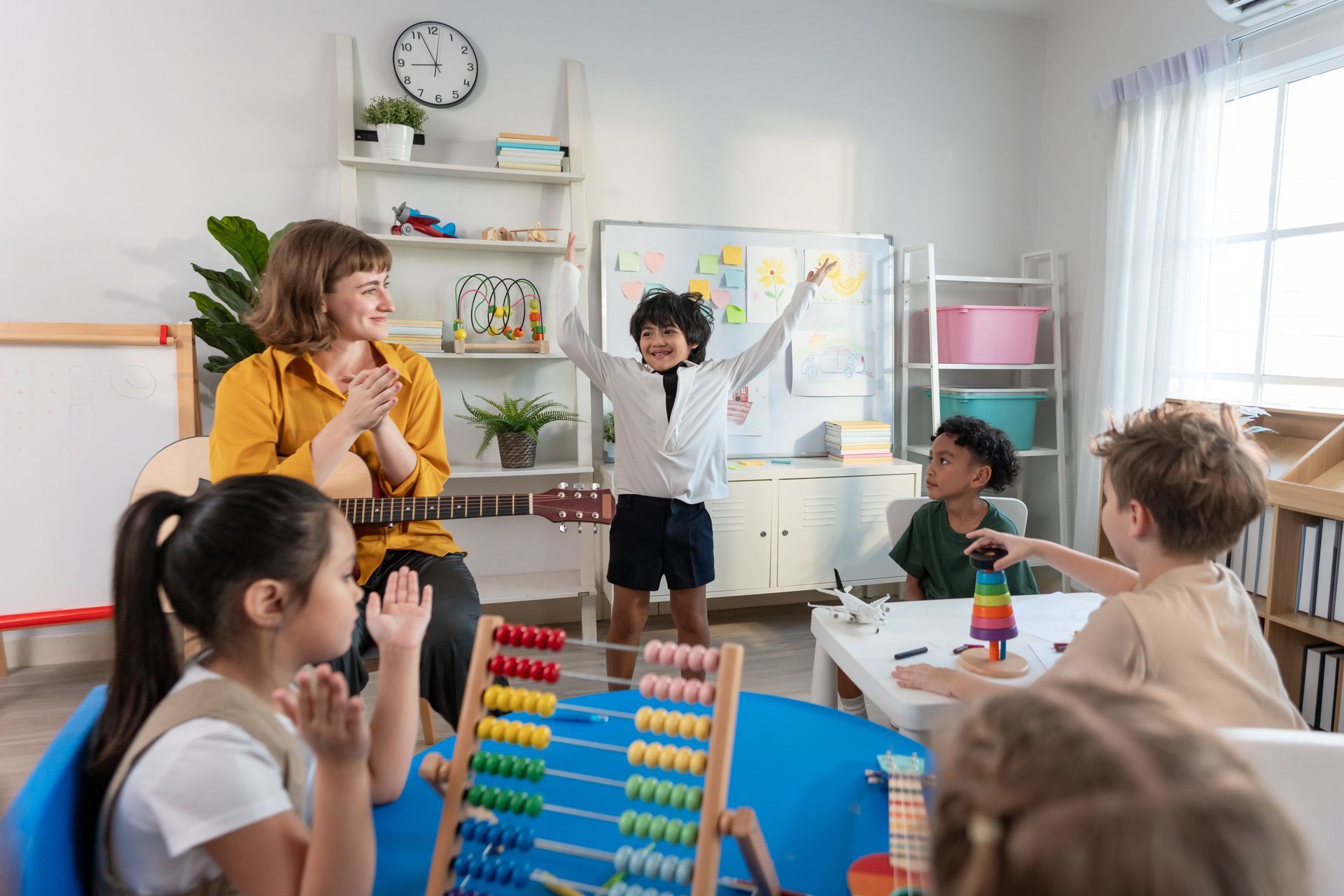 A teacher is teaching a group of children in a classroom.