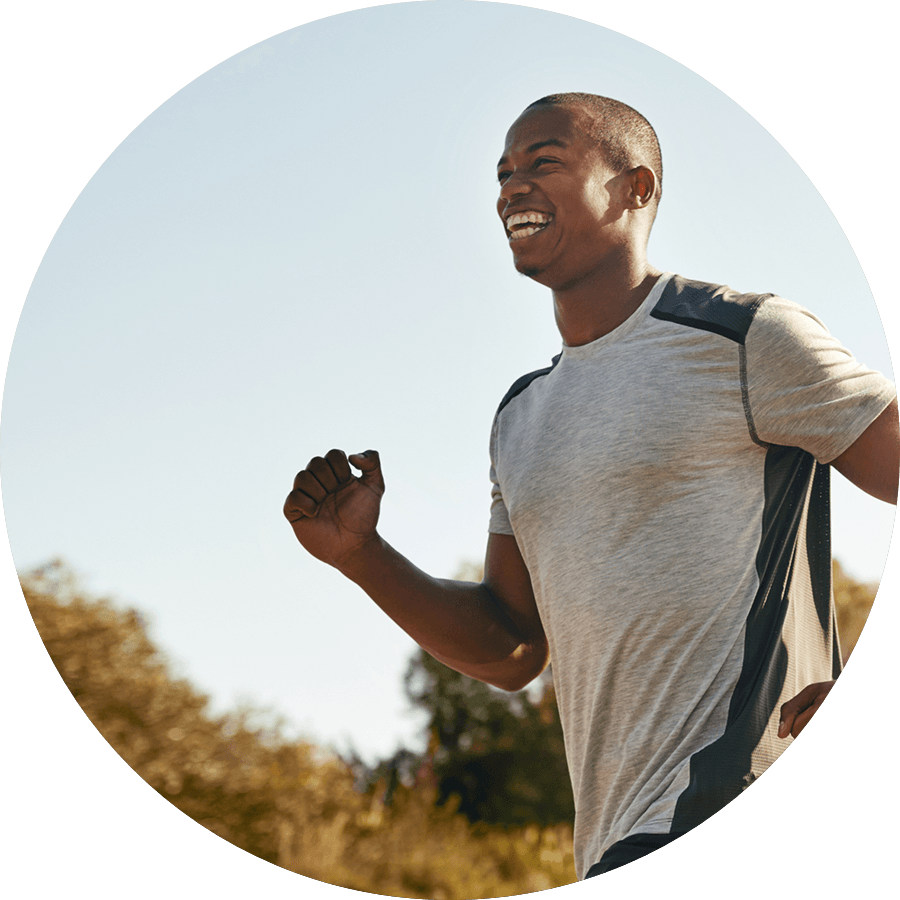A man is running in a field and smiling.