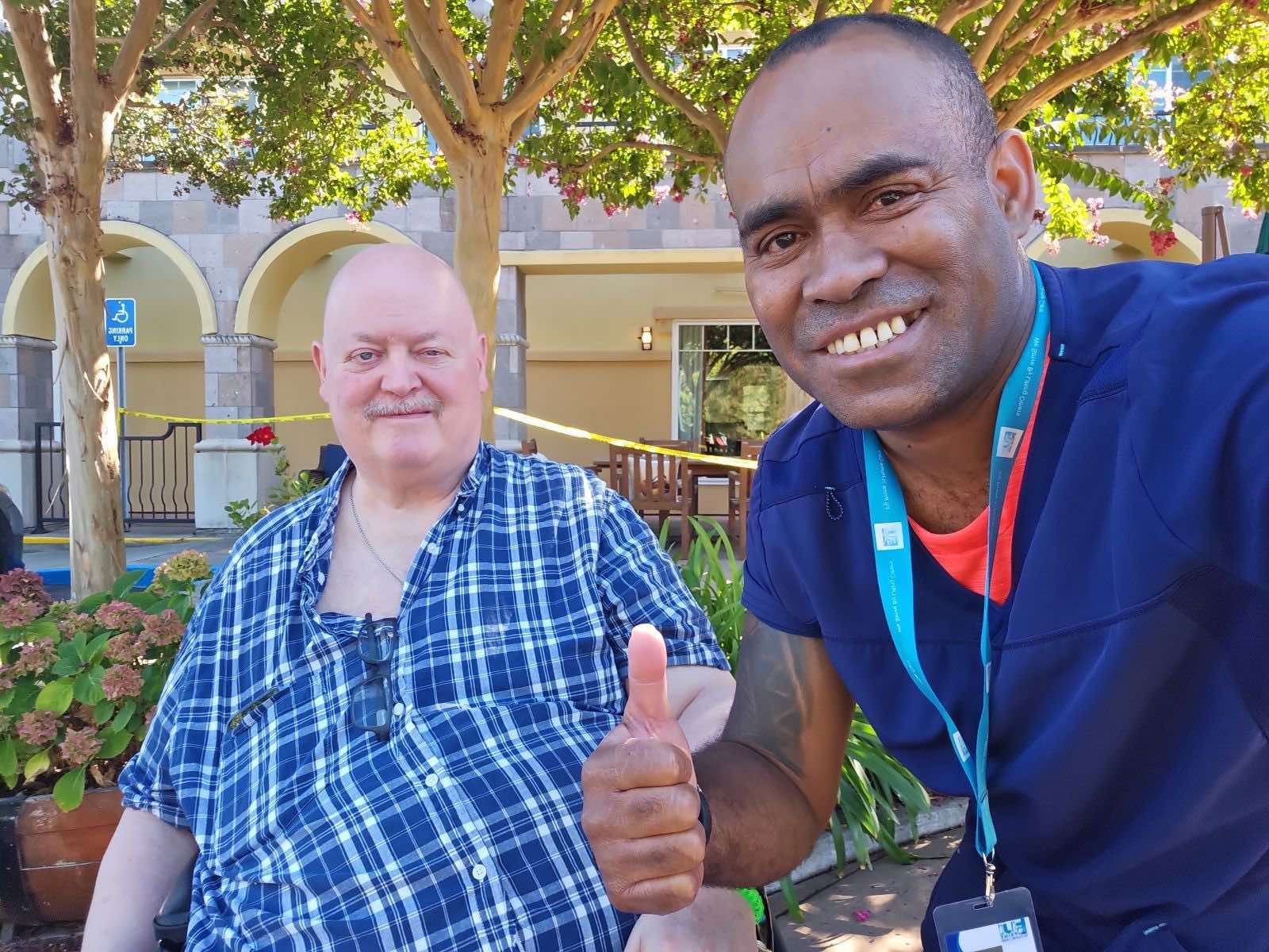 Caregiver assisting a person indoors, helping with walking.