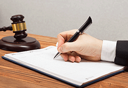Person Signing Legal Document With Gavel Person Signing Legal Document With Gavel