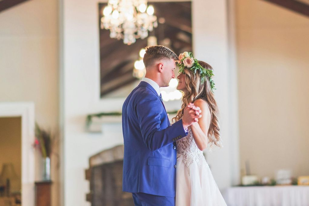 A bride and groom are dancing together at their wedding reception.