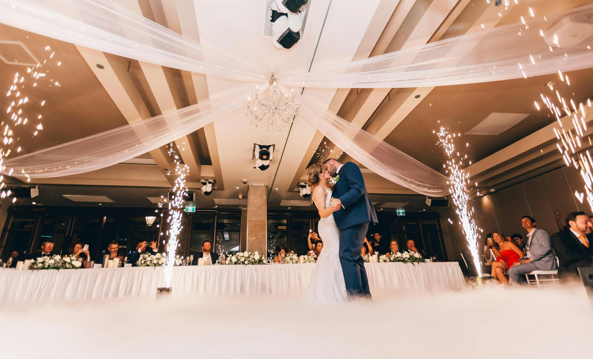 A bride and groom are dancing on a stage at their wedding reception.