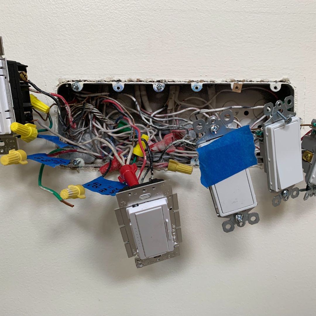 A bunch of wires are hanging from a wall.