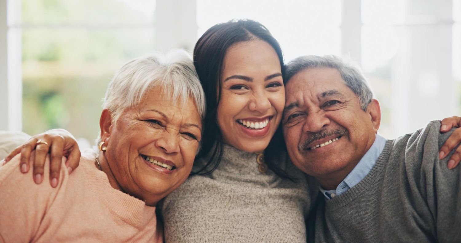A young woman is posing for a picture with her parents.