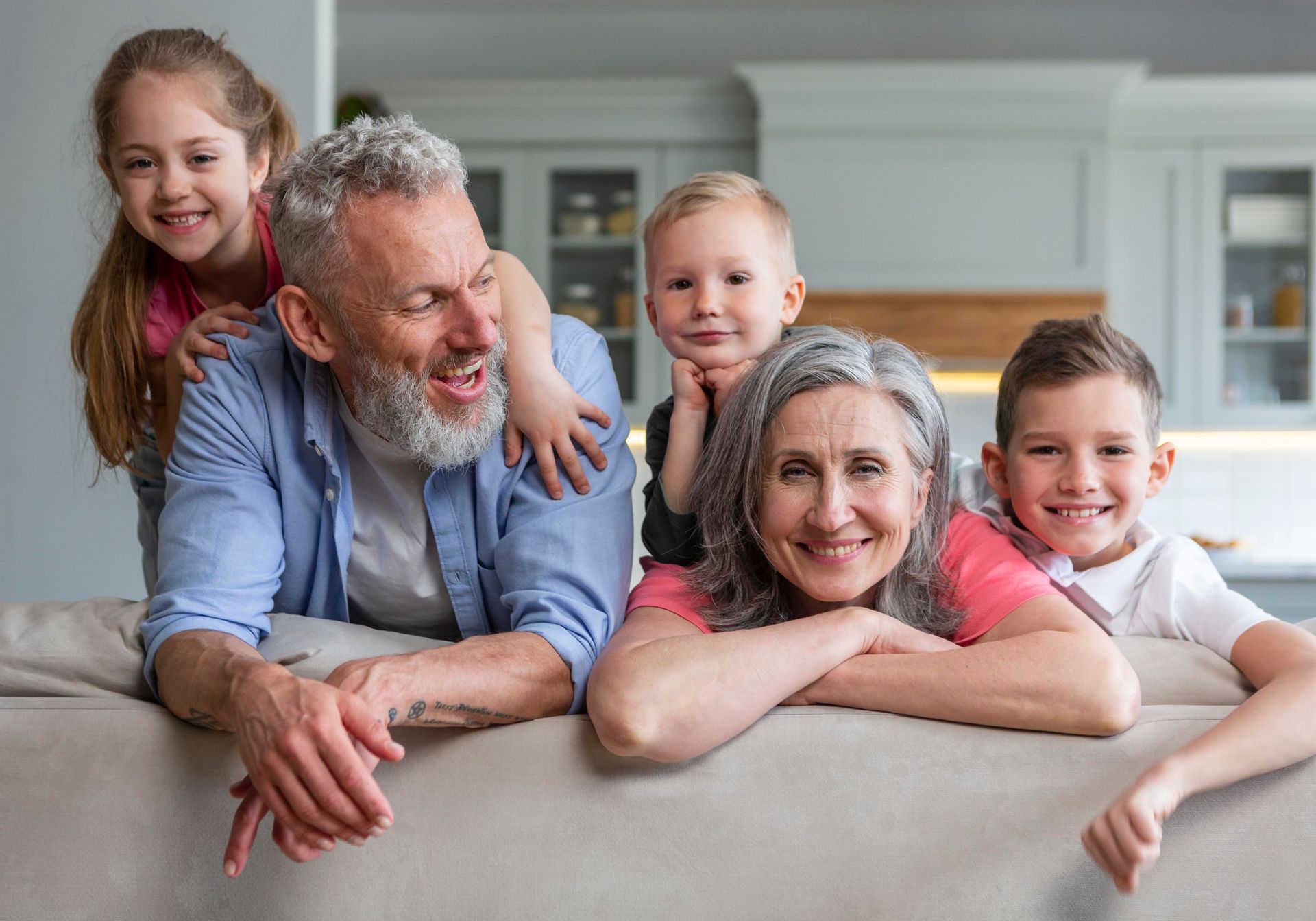 A family is posing for a picture while laying on a couch.