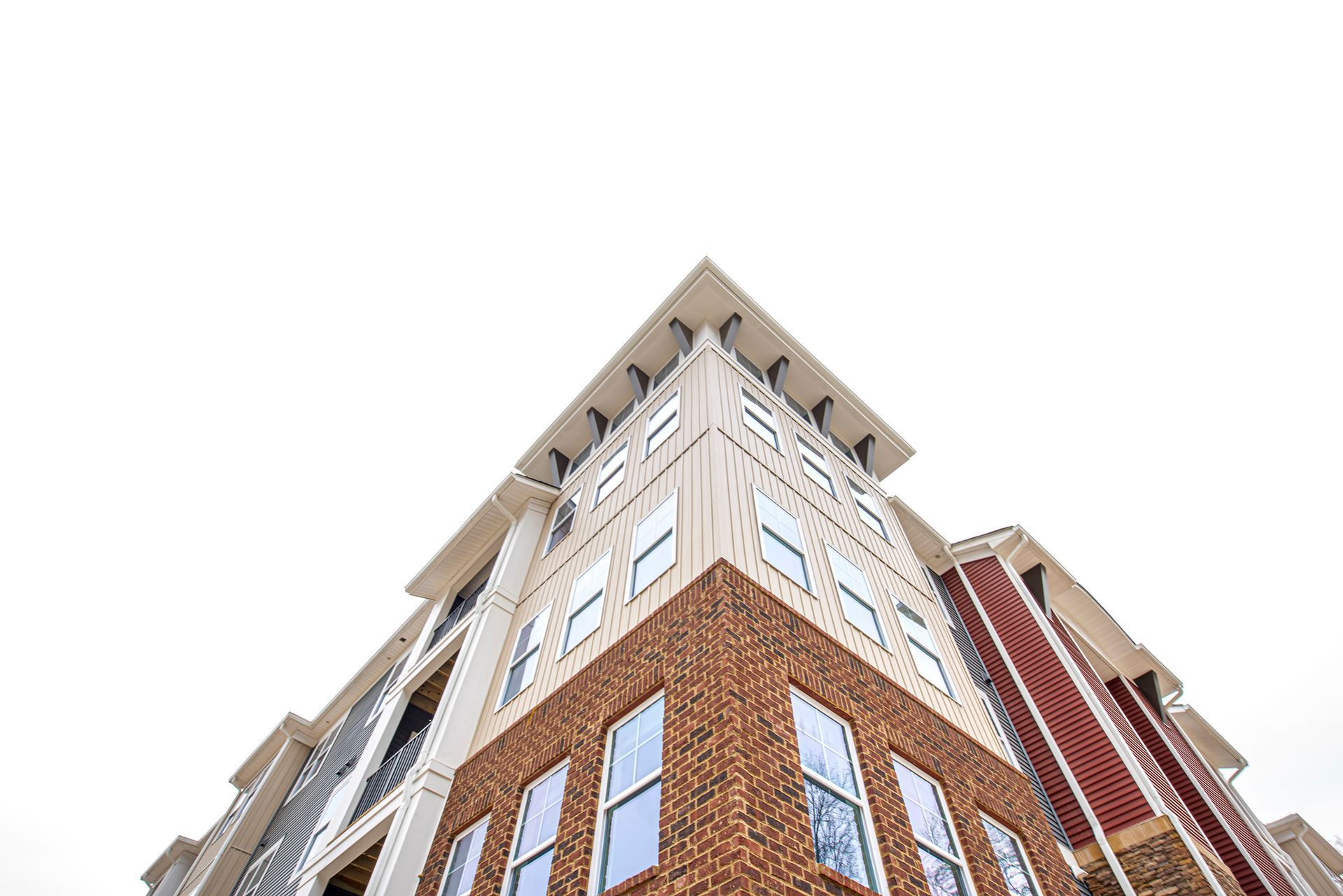 Looking up at the corner of a large apartment building.