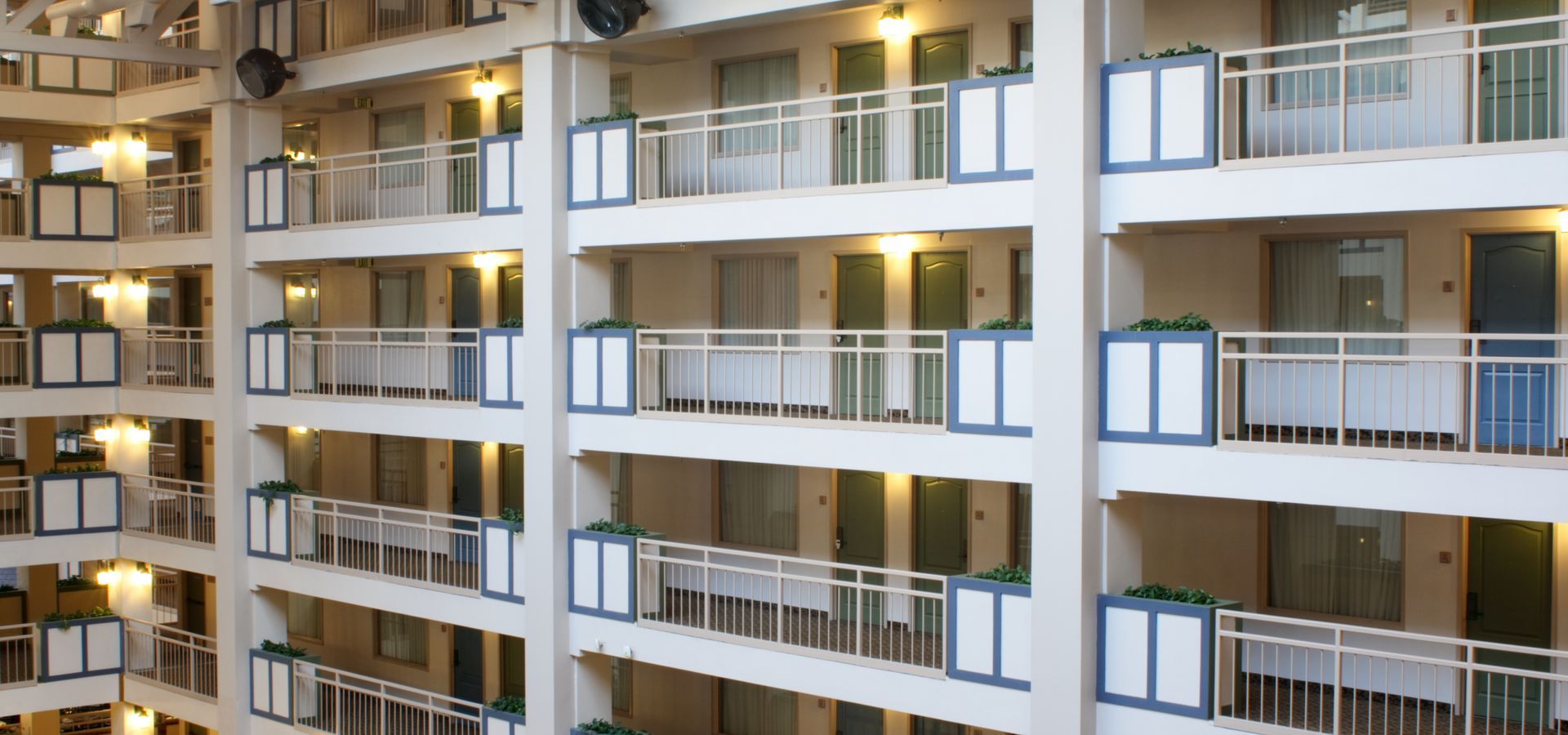 A large apartment building with many balconies and doors