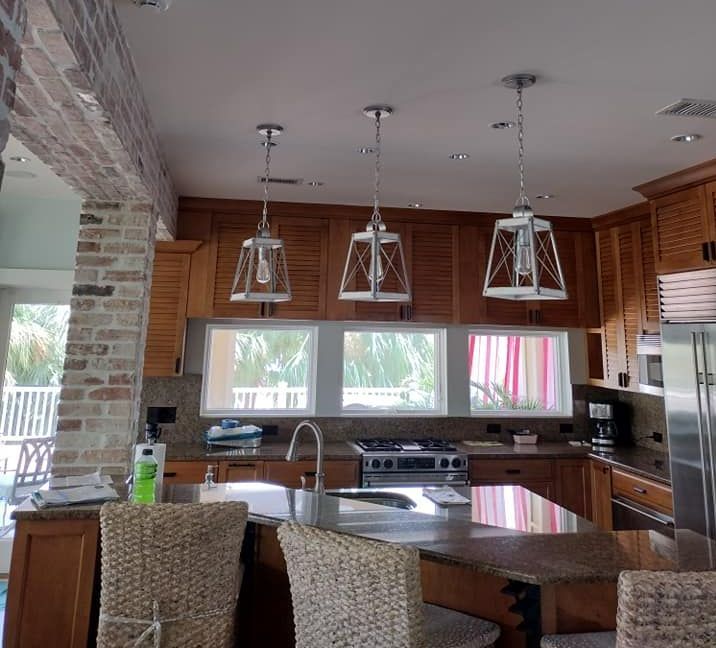 A kitchen with wooden cabinets and wicker chairs