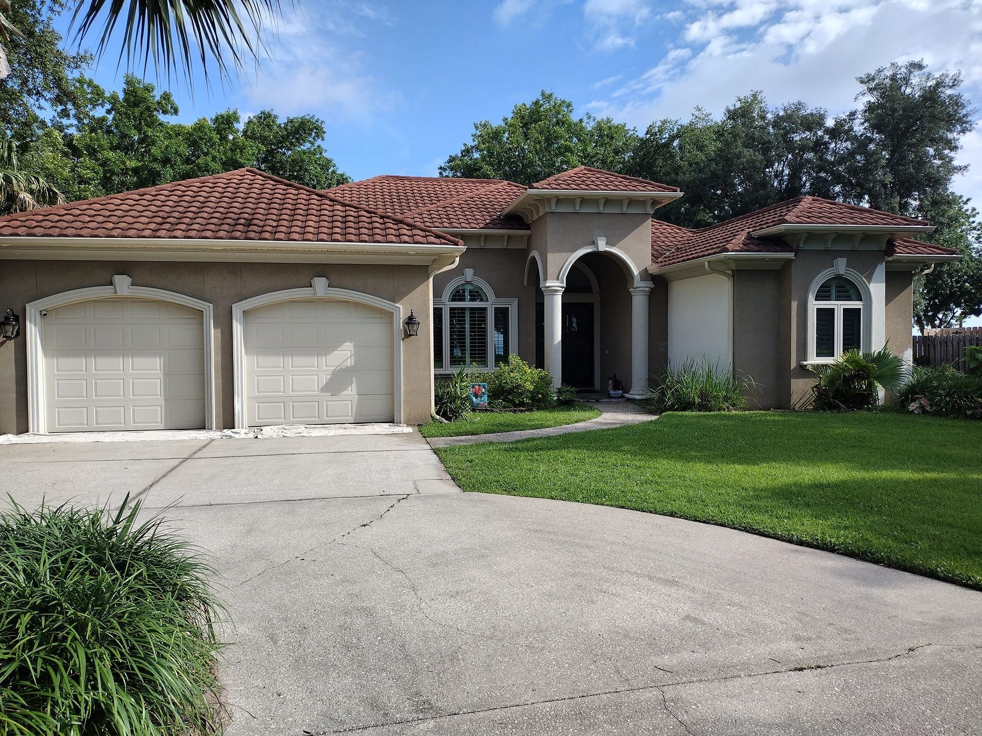 A large house with three garage doors and a driveway