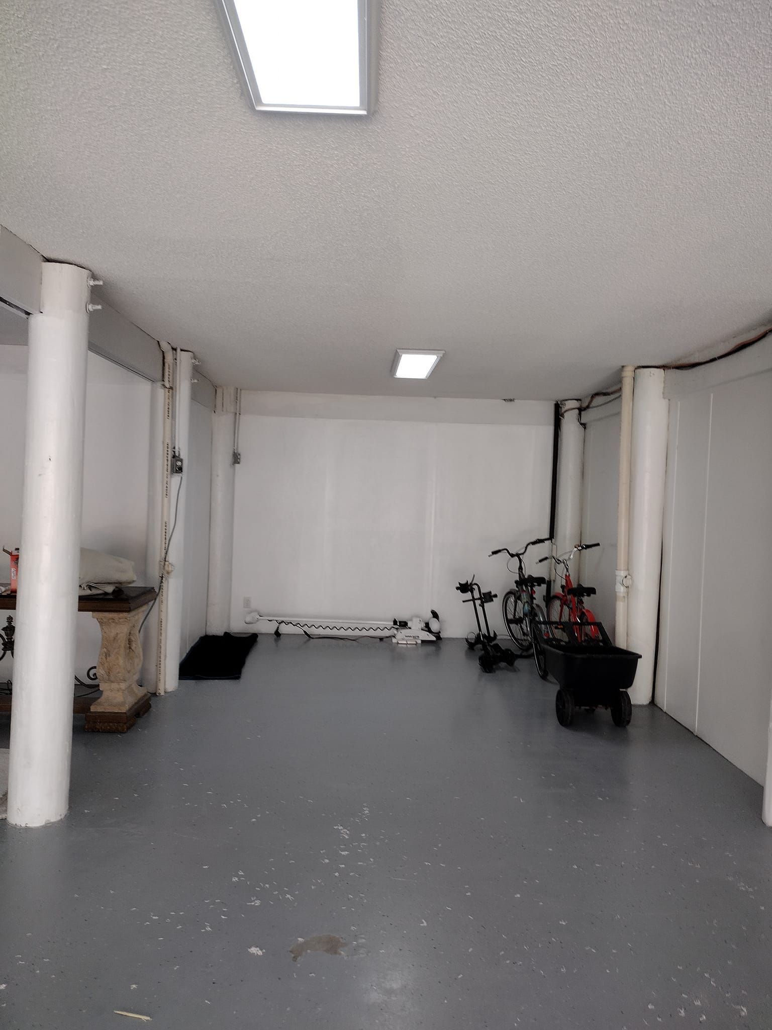 An empty garage with a walker and a bicycle in it