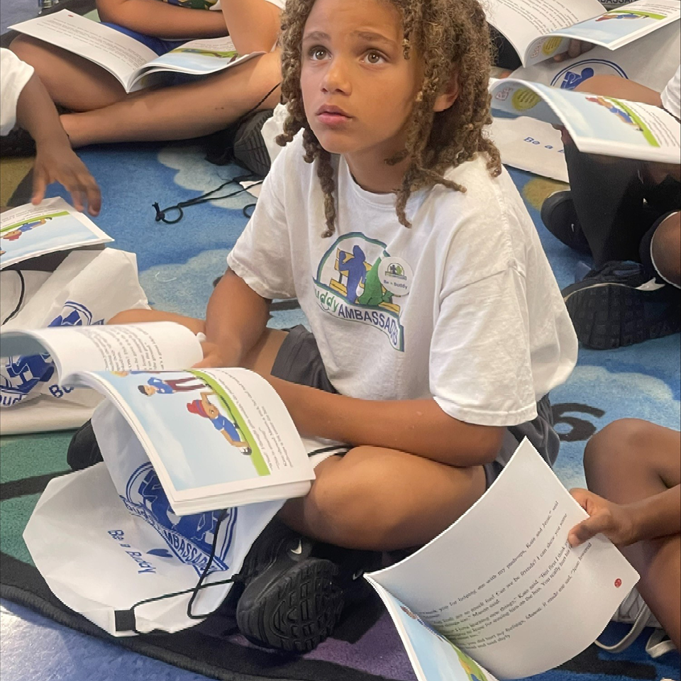 A young girl wearing a white shirt that says