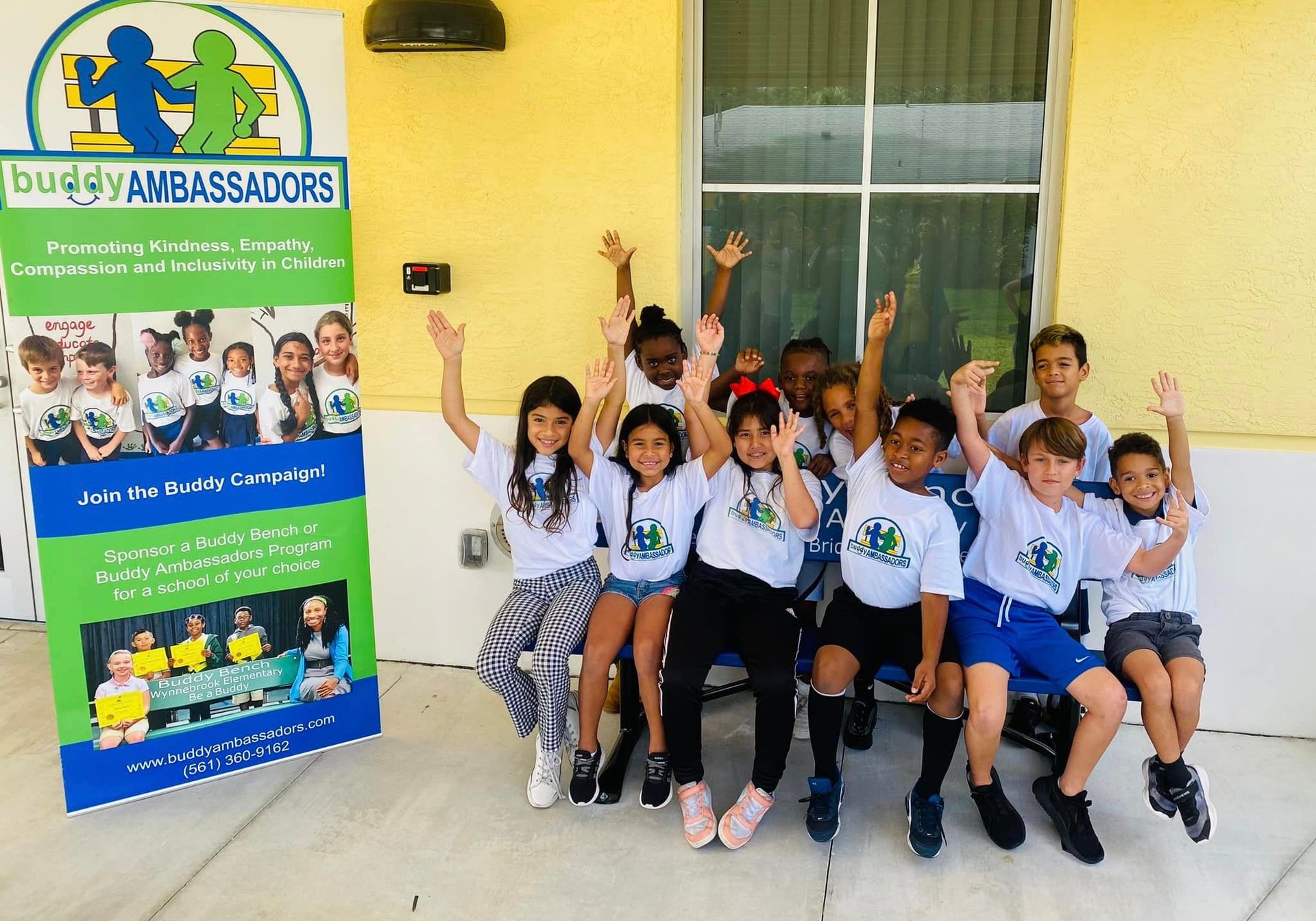 A group of children are posing for a picture in front of a building.