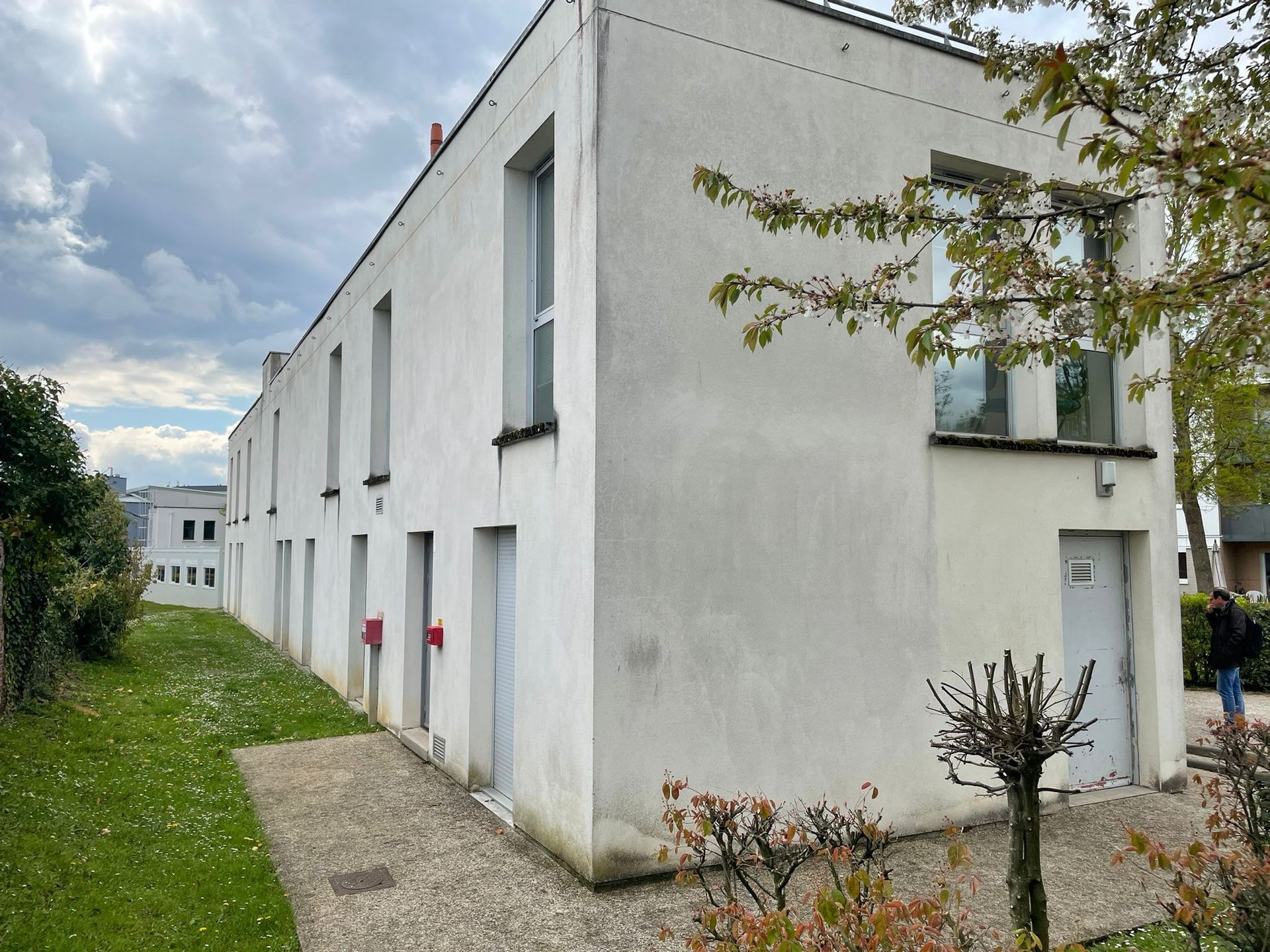 Un bâtiment blanc avec beaucoup de fenêtres et de portes avec notre entreprise de peinture normandie