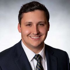 Man in suit smiling, looking at the camera.