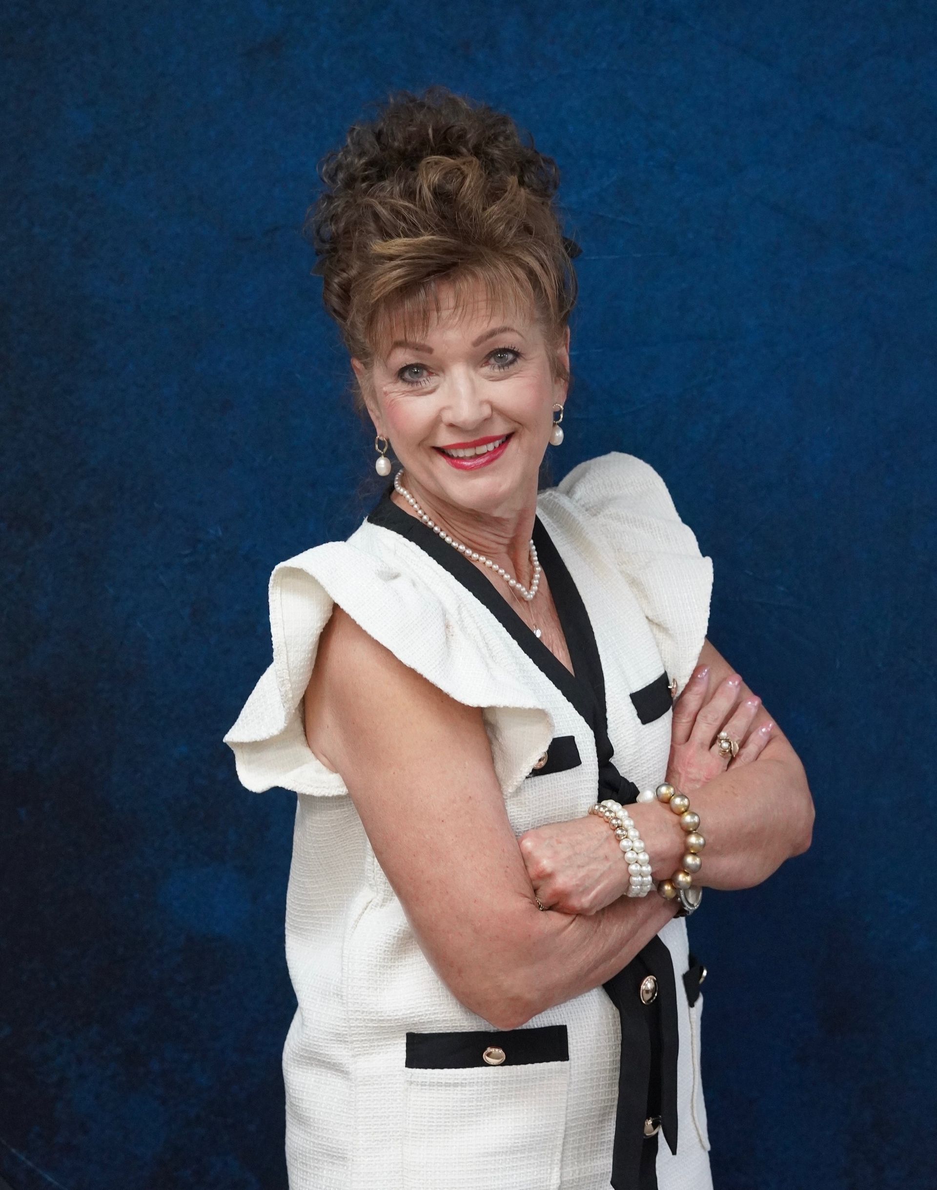Man in suit with purple striped tie smiles at the camera.
