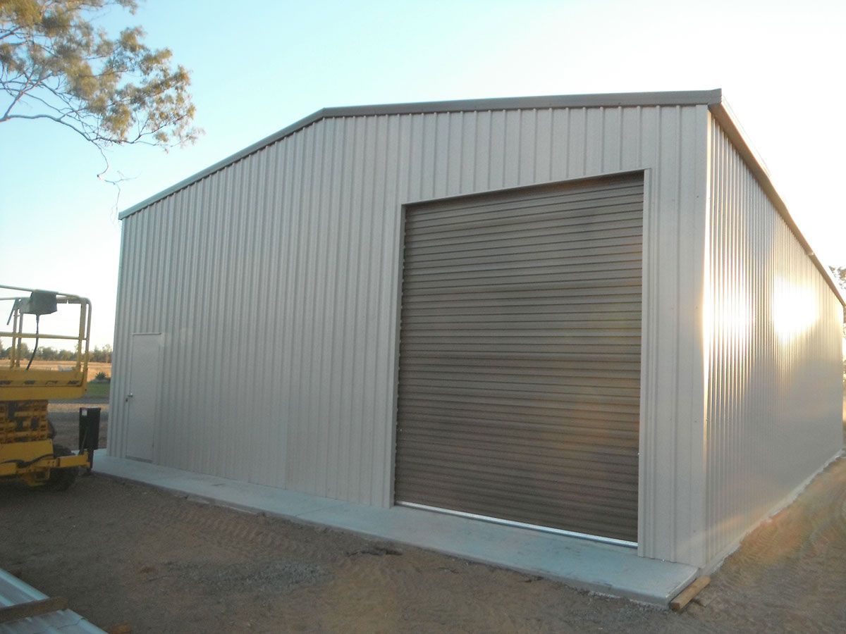 A Large Shed with Colour White with a Branch of Tree on the Side | Gin Gin, Qld | Shed Constructions Qld