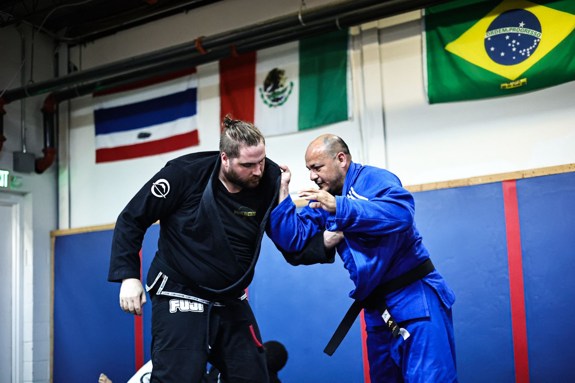 Adults practicing controlled Jiu-Jitsu sparring at Infinity Jiu-jitsu and Judo in Timonium, MD to reduce stress.