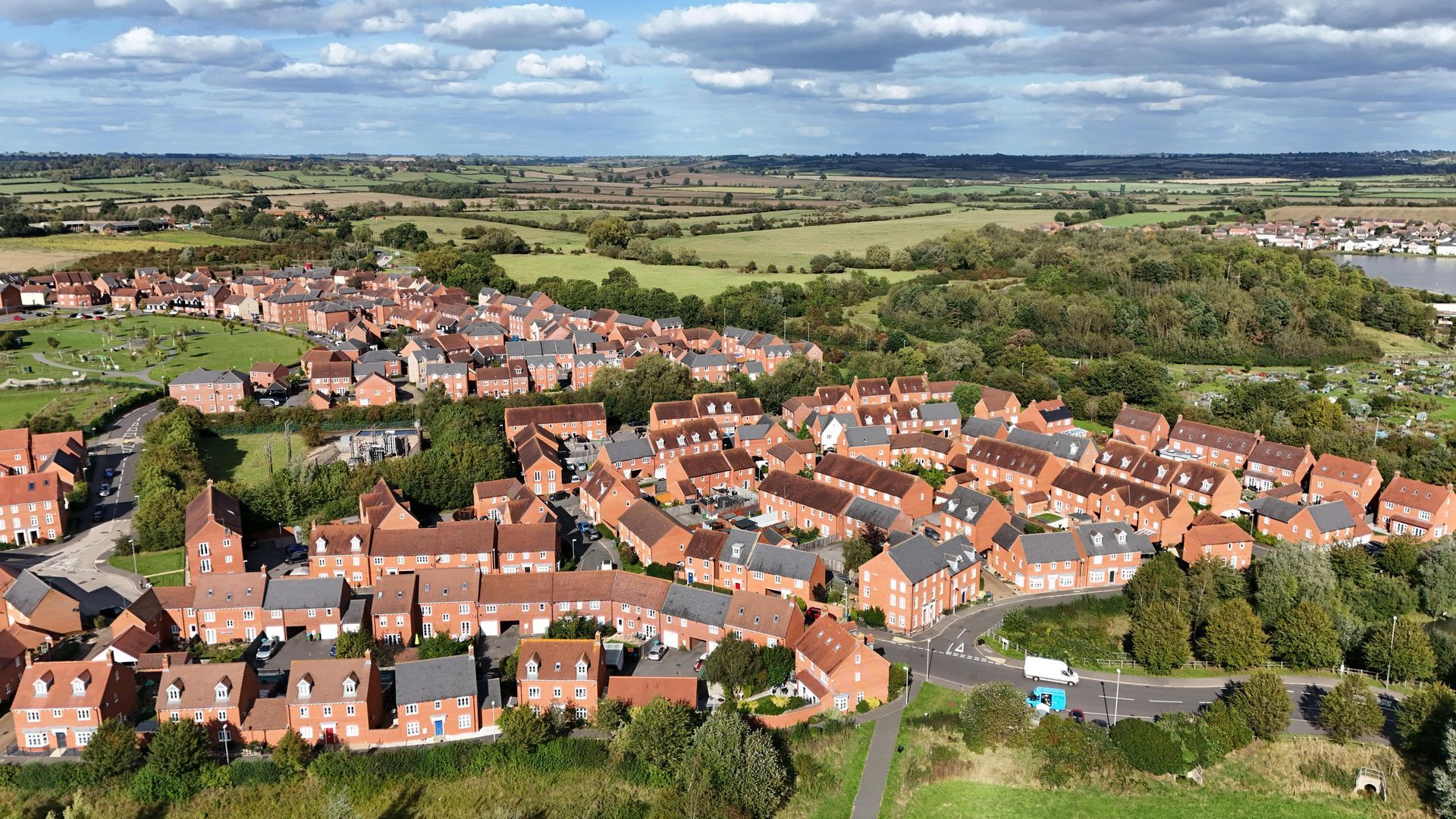 An aerial view of a small town surrounded by fields and trees.