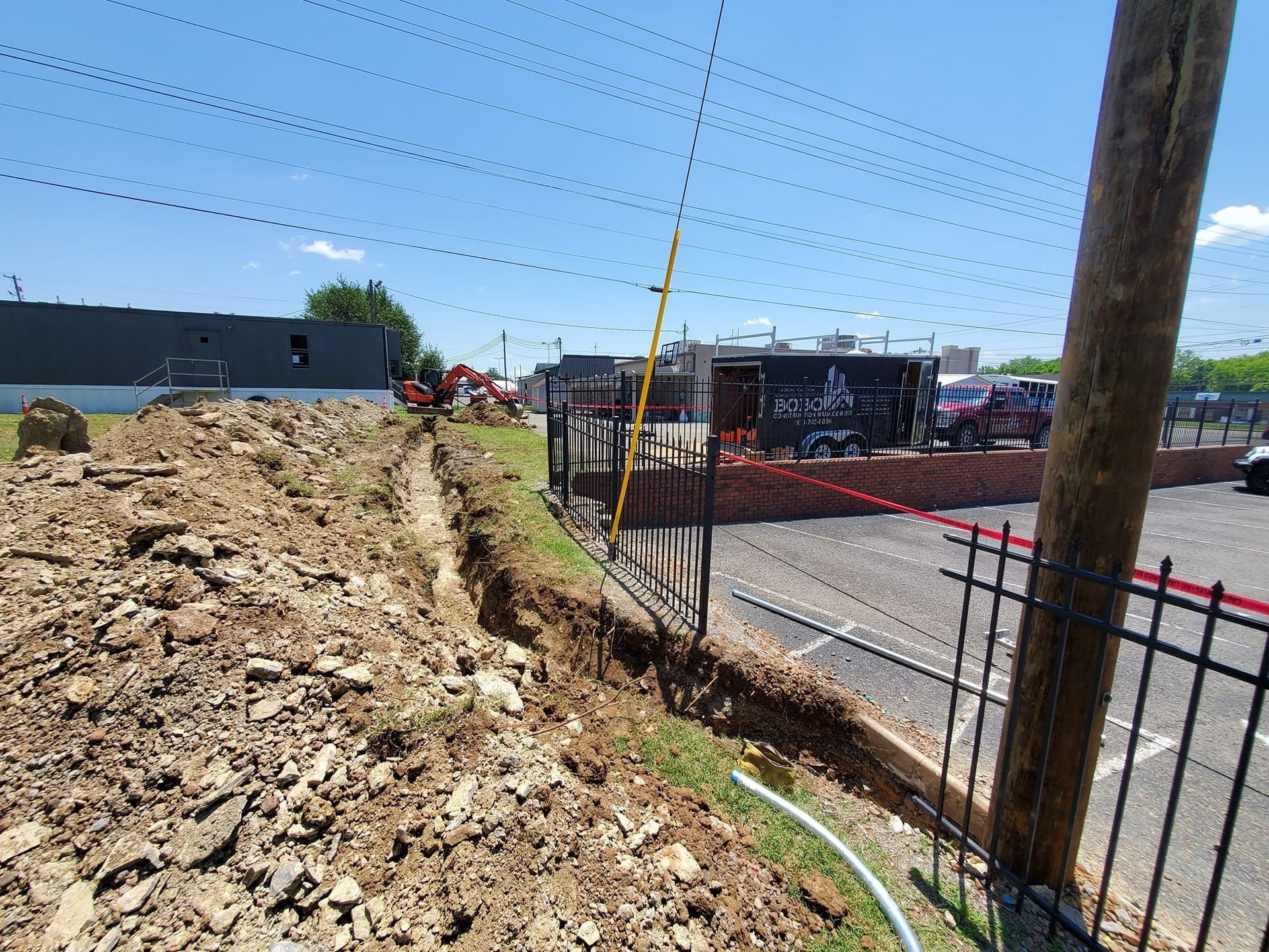 A large pile of dirt is sitting next to a fence.