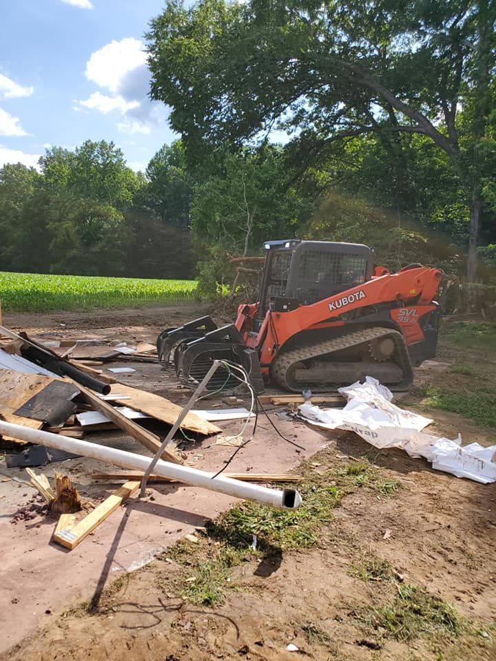 A bulldozer is sitting on top of a pile of rubble in a field.