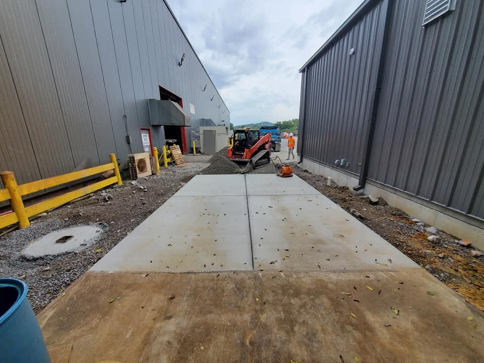 A concrete walkway is being built in front of a building.
