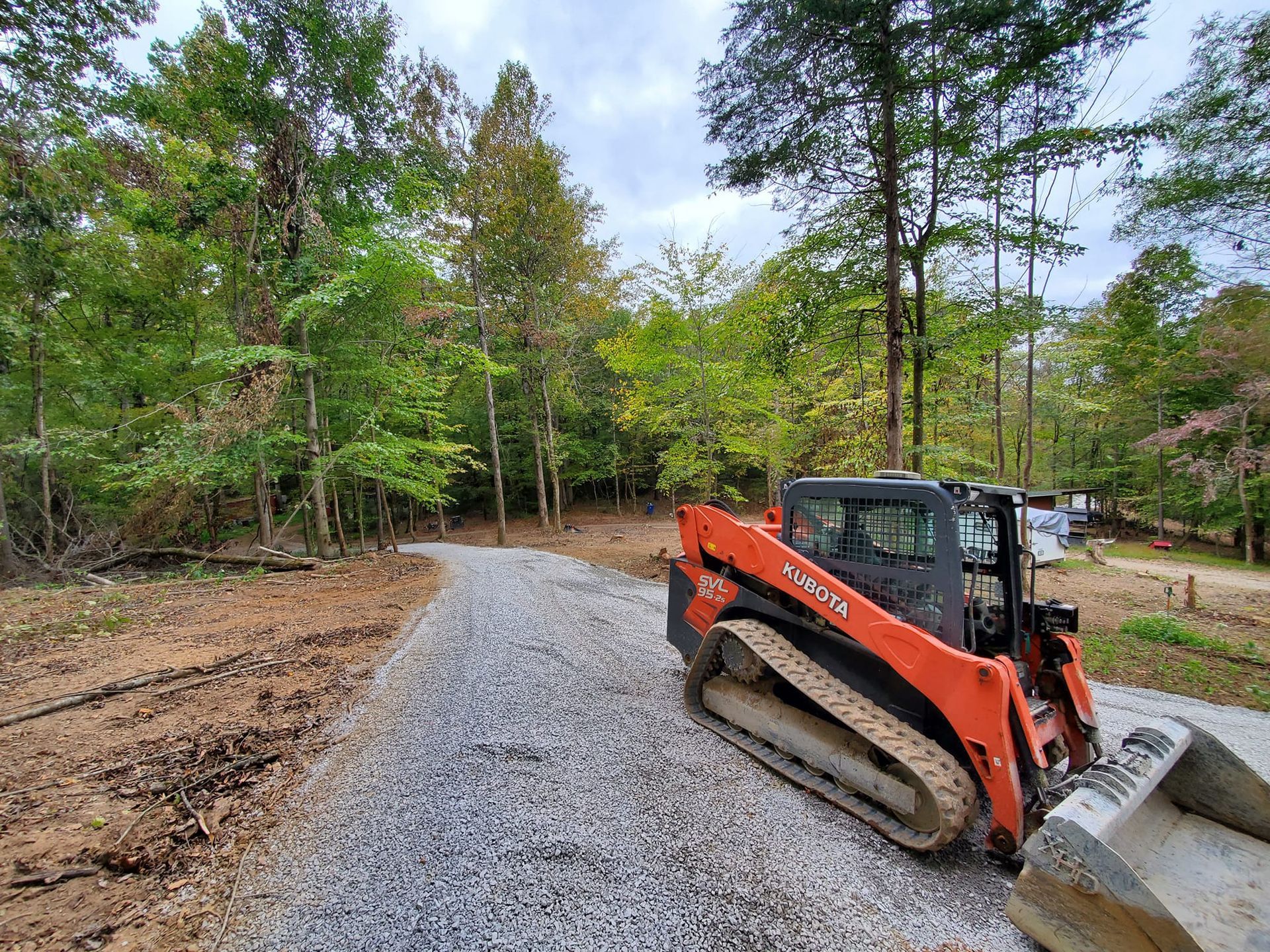 A bulldozer is parked on the side of a gravel road.