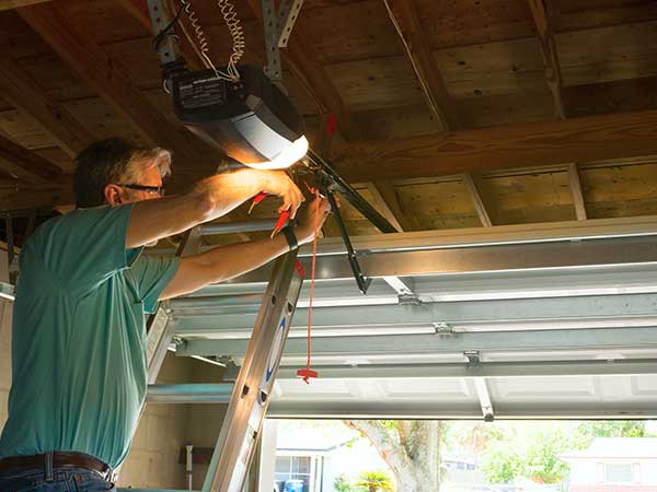 Man Fixing The Garage Doors — Jacksonville, FL — Associated Doors