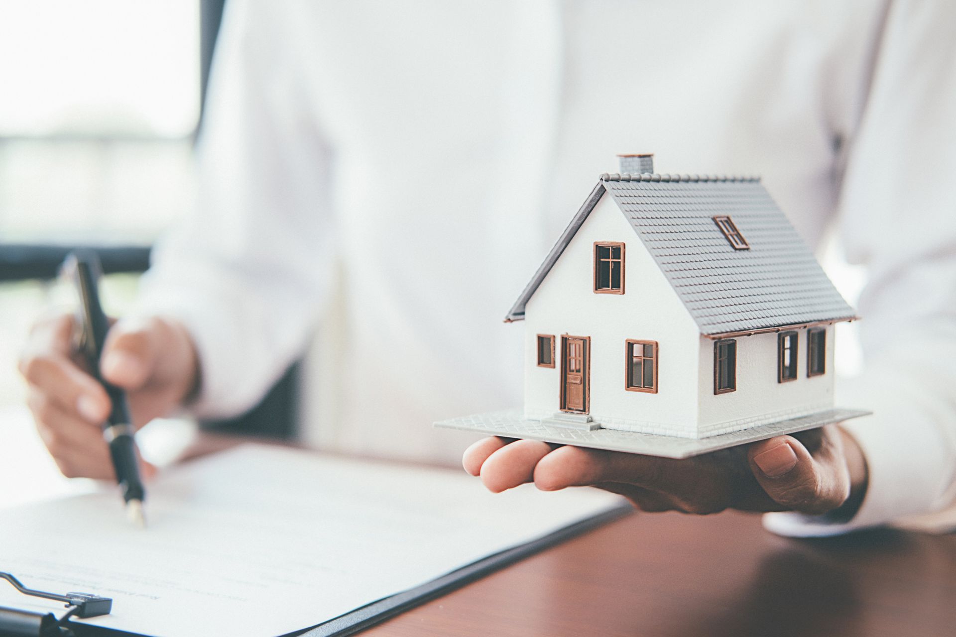 House model with real estate agent and customer discussing.