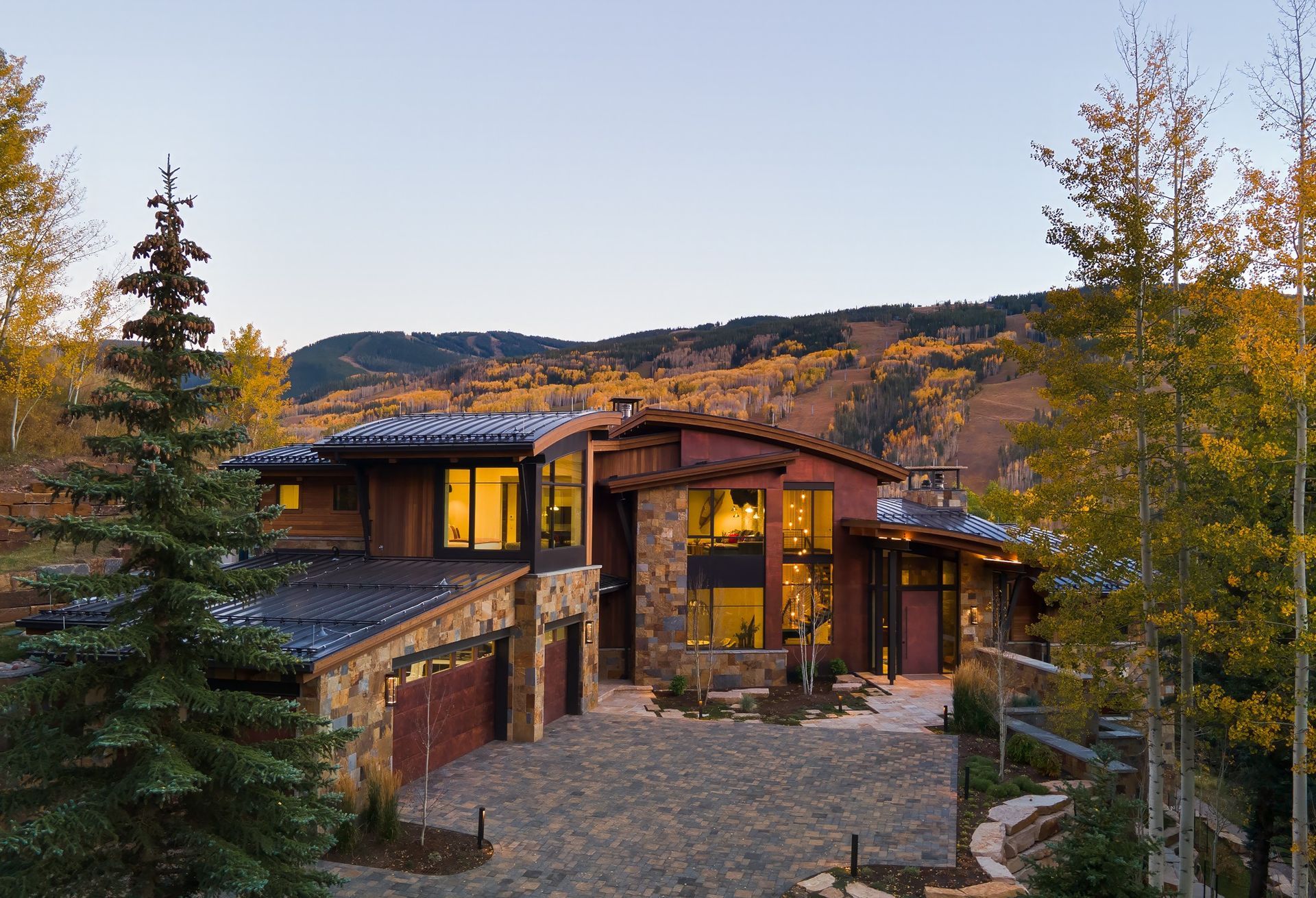 Perched in the stunning mountains of Colorado, this modern mountain retreat designed by Berglund Architects seamlessly blends contemporary design with natural materials. Expansive windows frame breathtaking views of the surrounding landscape, flooding the interior with natural light while connecting the home to its serene environment. The structure features a sophisticated combination of rusted steel, wood siding, and locally sourced stone, creating a warm and organic palette. A gently curved roofline and clean architectural lines enhance the home’s modern character, while spacious outdoor areas invite year-round enjoyment. Thoughtfully designed for both comfort and aesthetics, this residence exemplifies Berglund Architects' commitment to site-responsive architecture and timeless design.