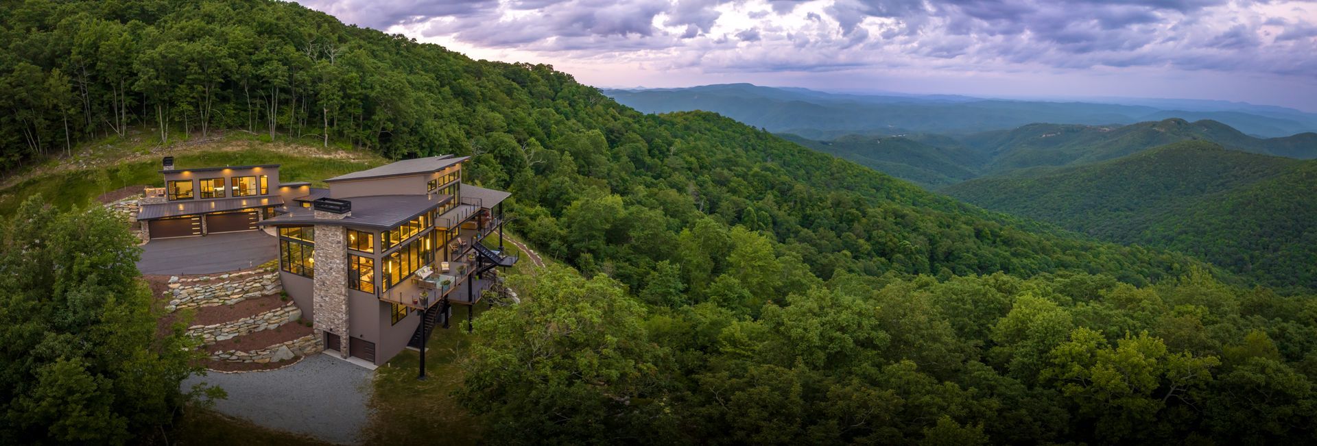 a large house with a lot of windows is sitting on top of a hill .