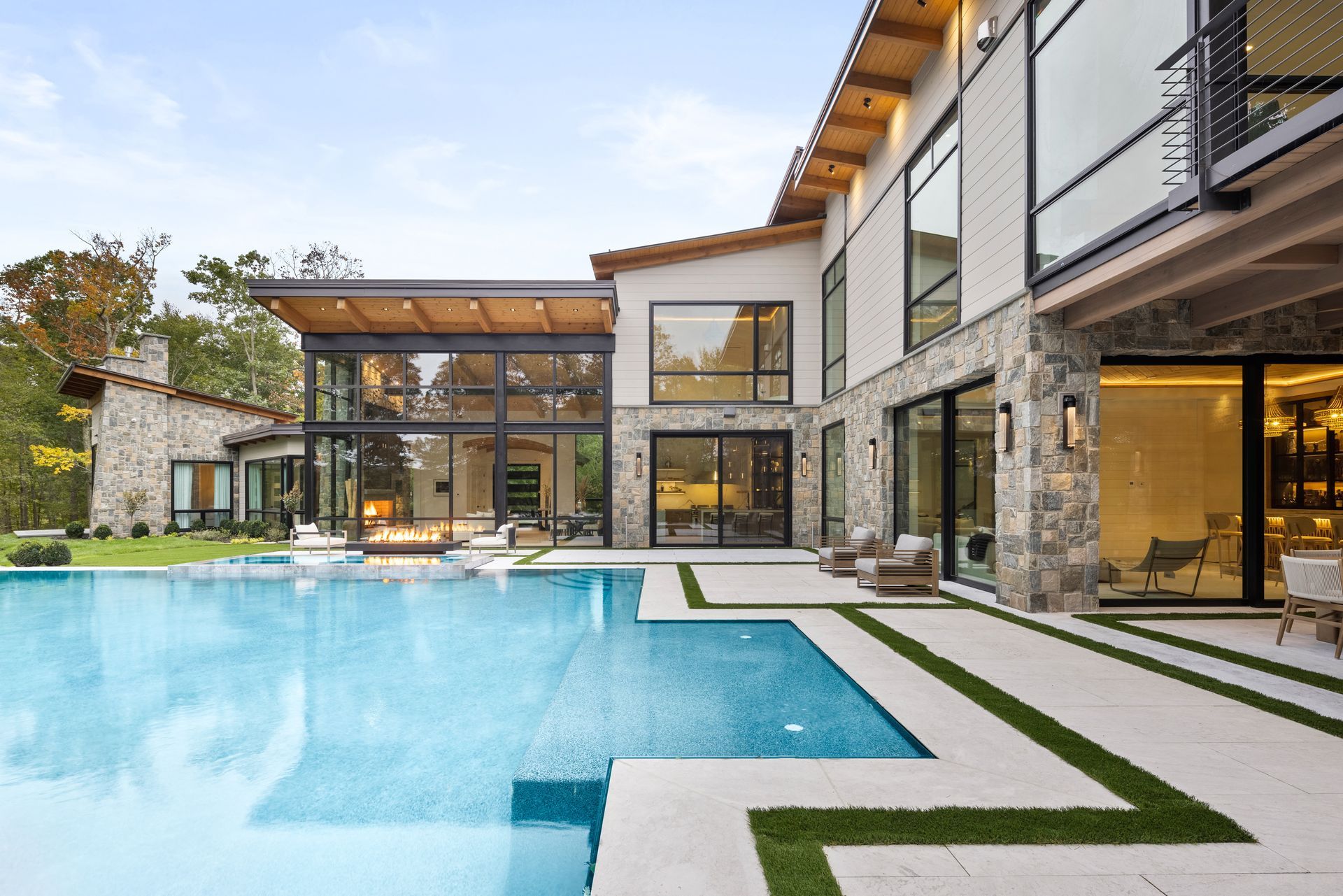 a large house with a lot of windows is sitting on top of a hill .