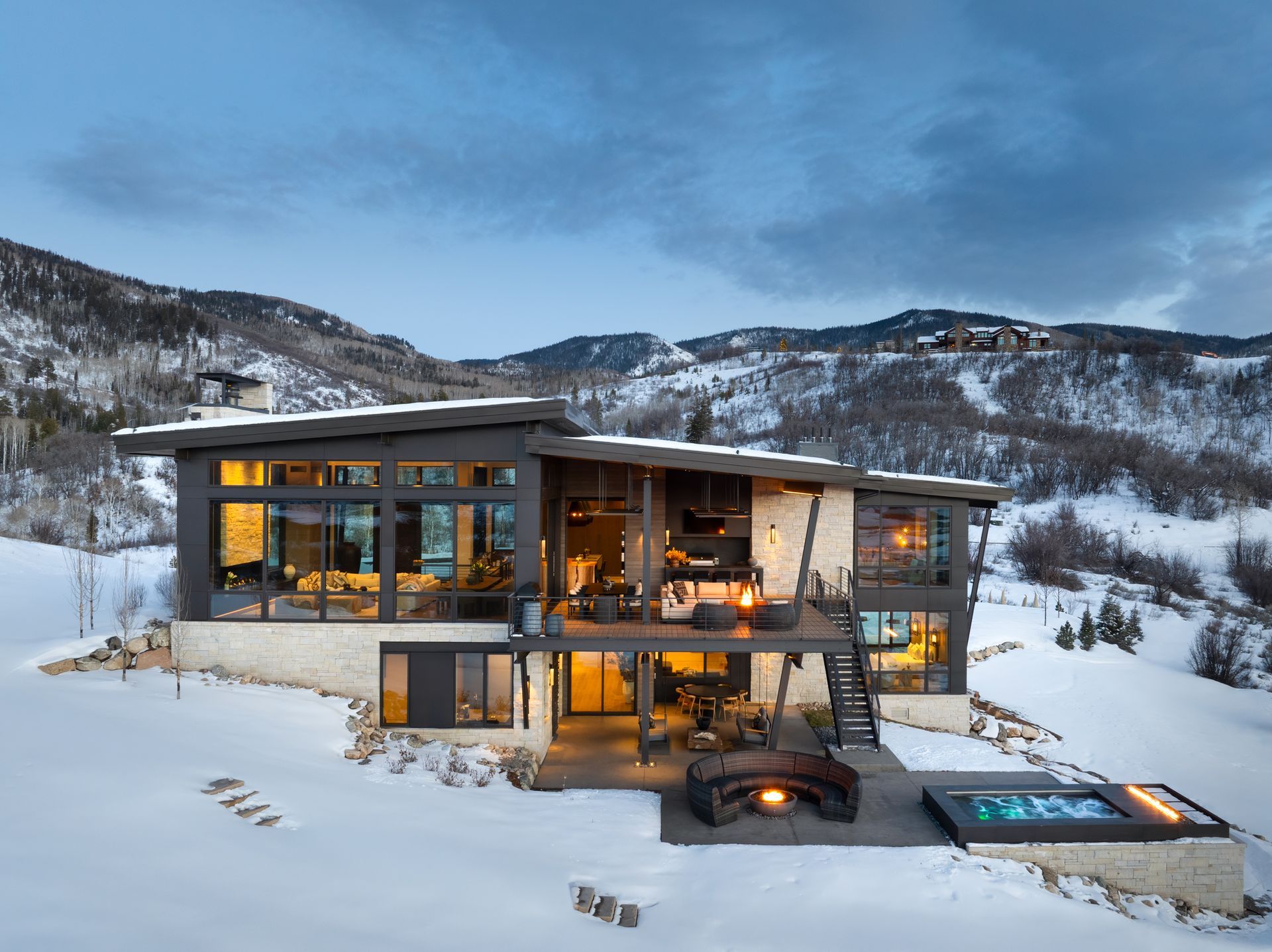An aerial view of a large house surrounded by trees and mountains.