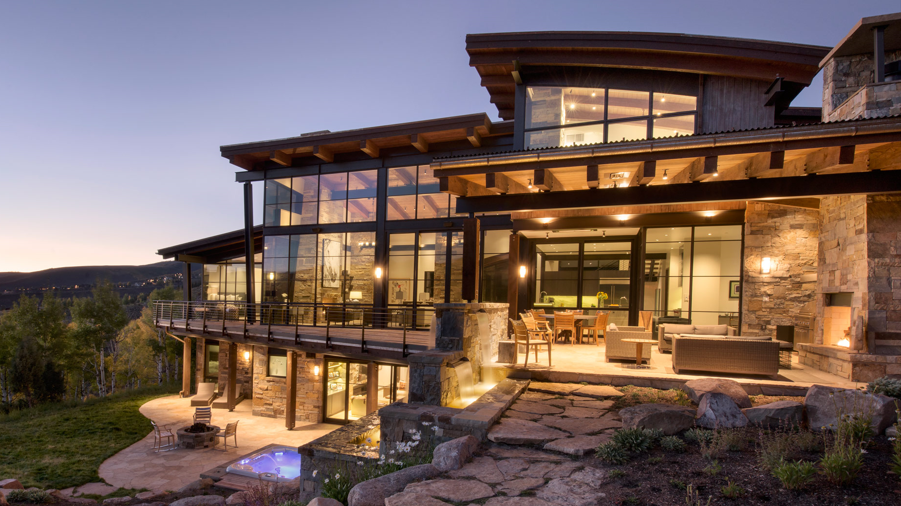 a large house with a lot of windows is sitting on top of a hill .