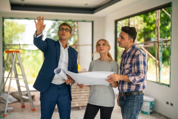 Male architect analyzing housing plan with a couple