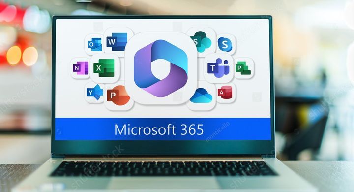 A laptop computer is sitting on a table with a microsoft 365 logo on the screen.