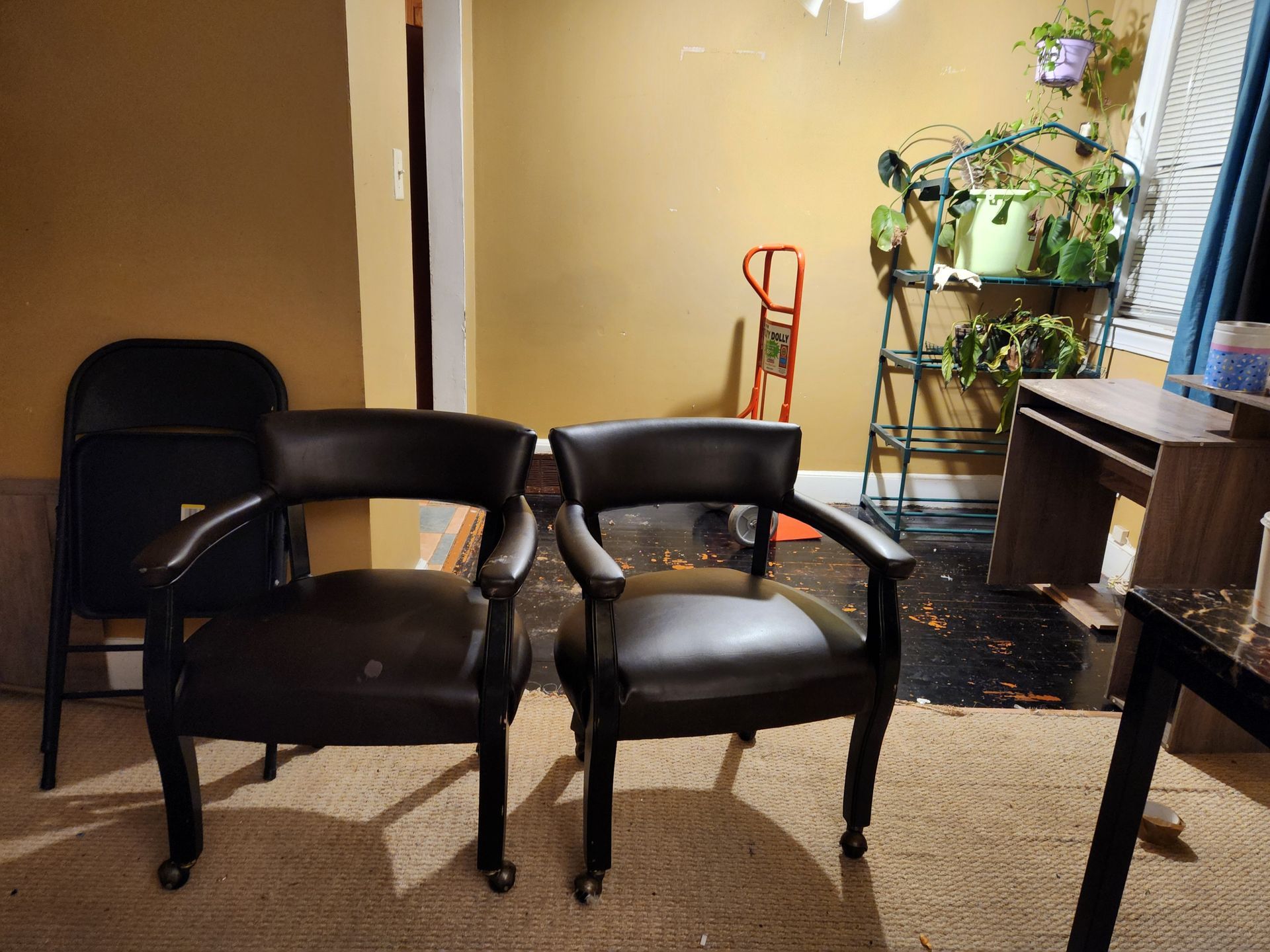 Two black chairs are sitting next to each other in a room.